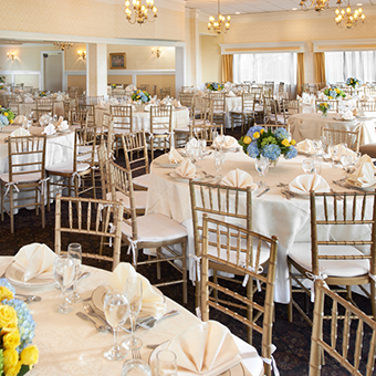 Indoor reception room setup with blue and yellow flowers for centerpieces.